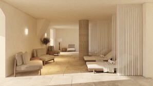 A spacious room with a large bed, two sofas, a chair, and a small table.