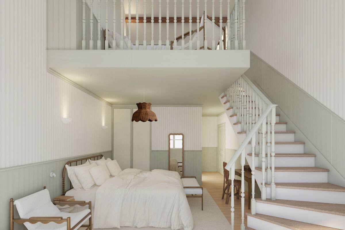 A bedroom with a large bed, a wooden nightstand, a chair, a desk, a hanging light fixture, and a staircase.