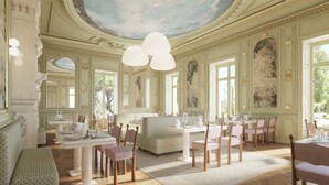 A grand dining room with ornate ceiling, large windows, and classic furniture.