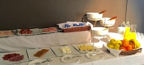 A buffet table with various food items including meats, cheeses, fruits, and beverages. - Balneario De Gravalos (Gravalos)