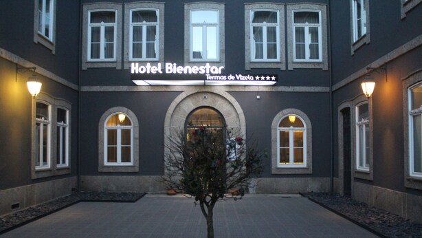 Hotel Bienestar with a central arched entrance, multiple windows, and a small tree in the courtyard. - Hotel Bienestar Termas De Vizela (Vizela)
