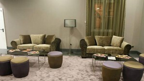 A living room with two sofas, a floor lamp, and several ottomans. - Hotel Bienestar Termas De Vizela (Vizela)