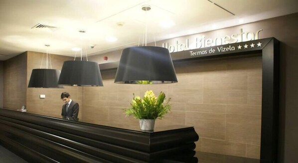 A reception desk with a sign reading "Hotel Bienestar" and "Termas de Vizea".