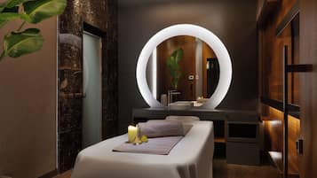 Un spa moderno con una camilla de masaje, un espejo grande y un tocador de madera.
