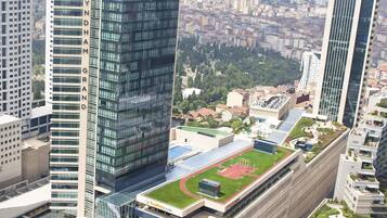 A modern building with a prominent 'Wyndham Grand' sign, surrounded by other high-rise buildings and a green park area.