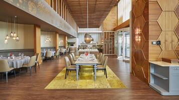 A spacious dining area with a long table set for six, surrounded by chairs.
