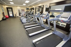 A gym with treadmills, exercise balls, and a mirror. - Hampton Inn & Suites Oklahoma City Airport (Oklahoma City)
