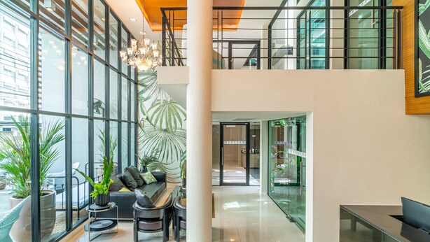 A modern lobby with a seating area, large windows, and a staircase. - Amber Boutique Silom Hotel (Bangkok)