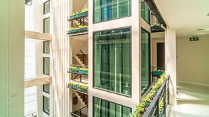 A multi-story building with balconies, large windows, and a staircase. - Amber Boutique Silom Hotel (Bangkok)