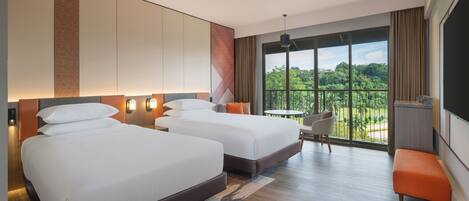 A hotel room with two beds, a balcony with a view, and a small table with chairs.