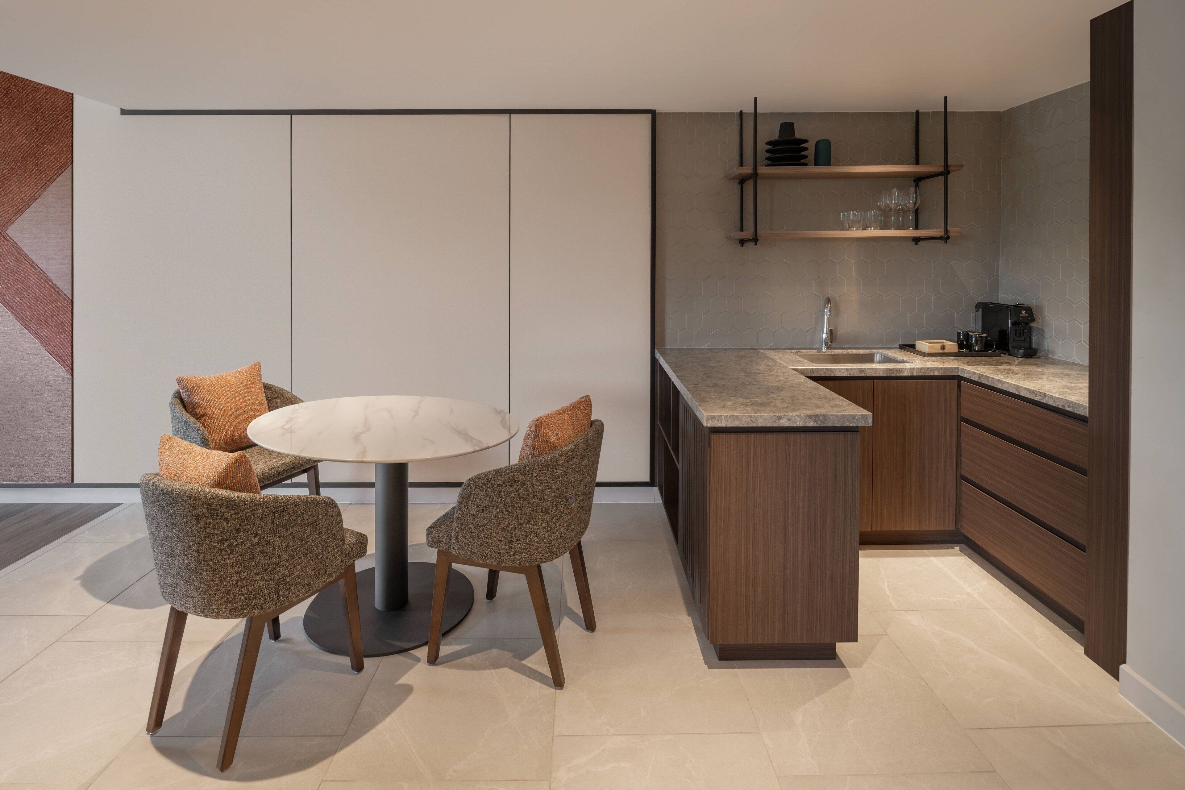 A modern kitchen with a central island, wooden cabinets, and a built-in sink.