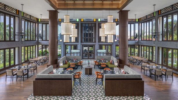 A spacious indoor area with large windows, multiple seating arrangements, and hanging chandeliers. - Palm Garden Hotel, Putrajaya, a Tribute Portfolio Hotel (Serdang)