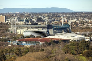 A stadium with multiple tiers of seating, surrounded by urban buildings and greenery. - WRAP on Southbank (Southbank)