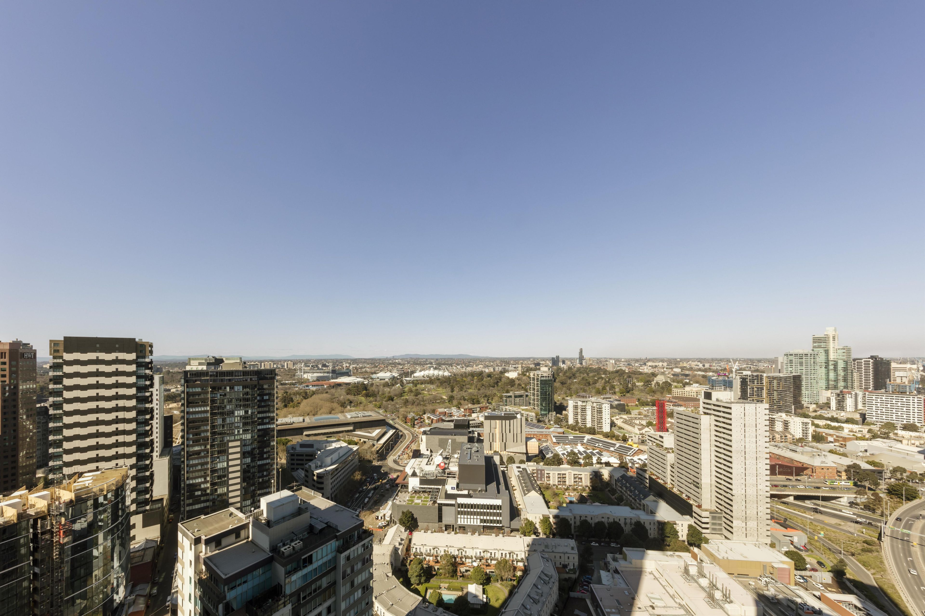 A cityscape with high-rise buildings, roads, and a clear sky.