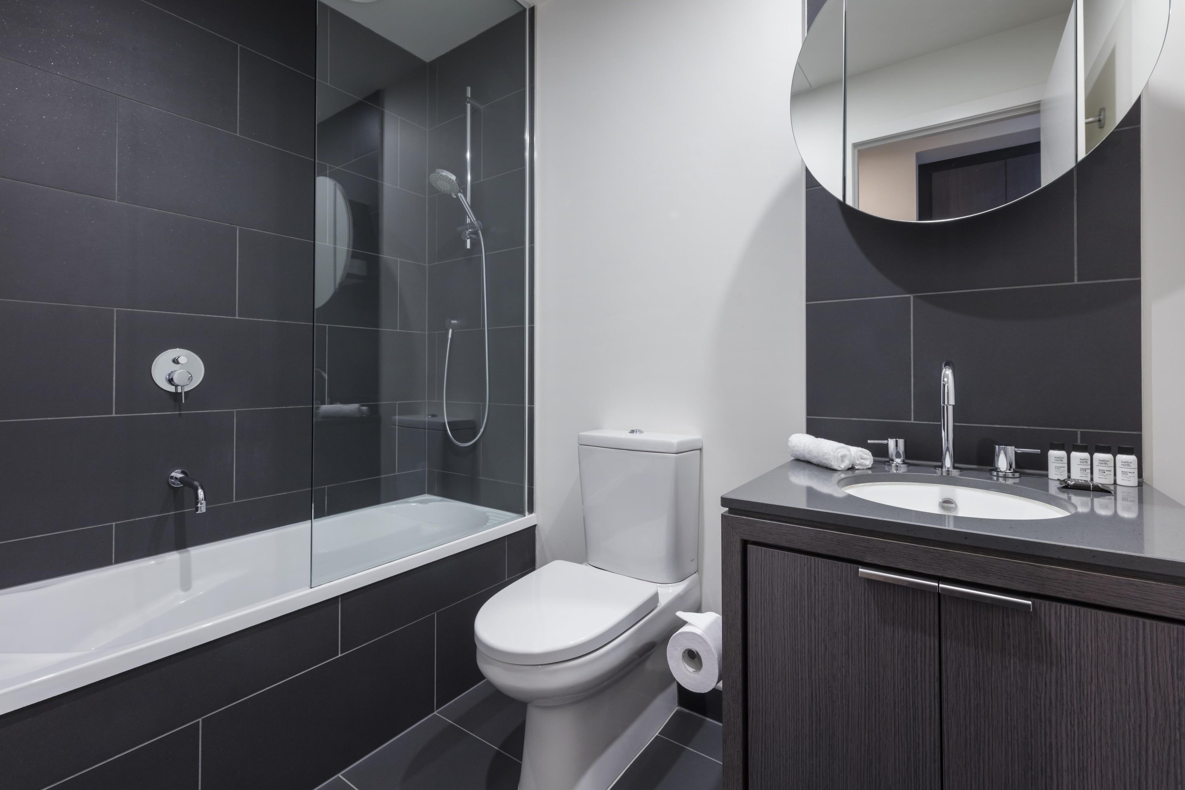 A modern bathroom with a bathtub, toilet, and sink.