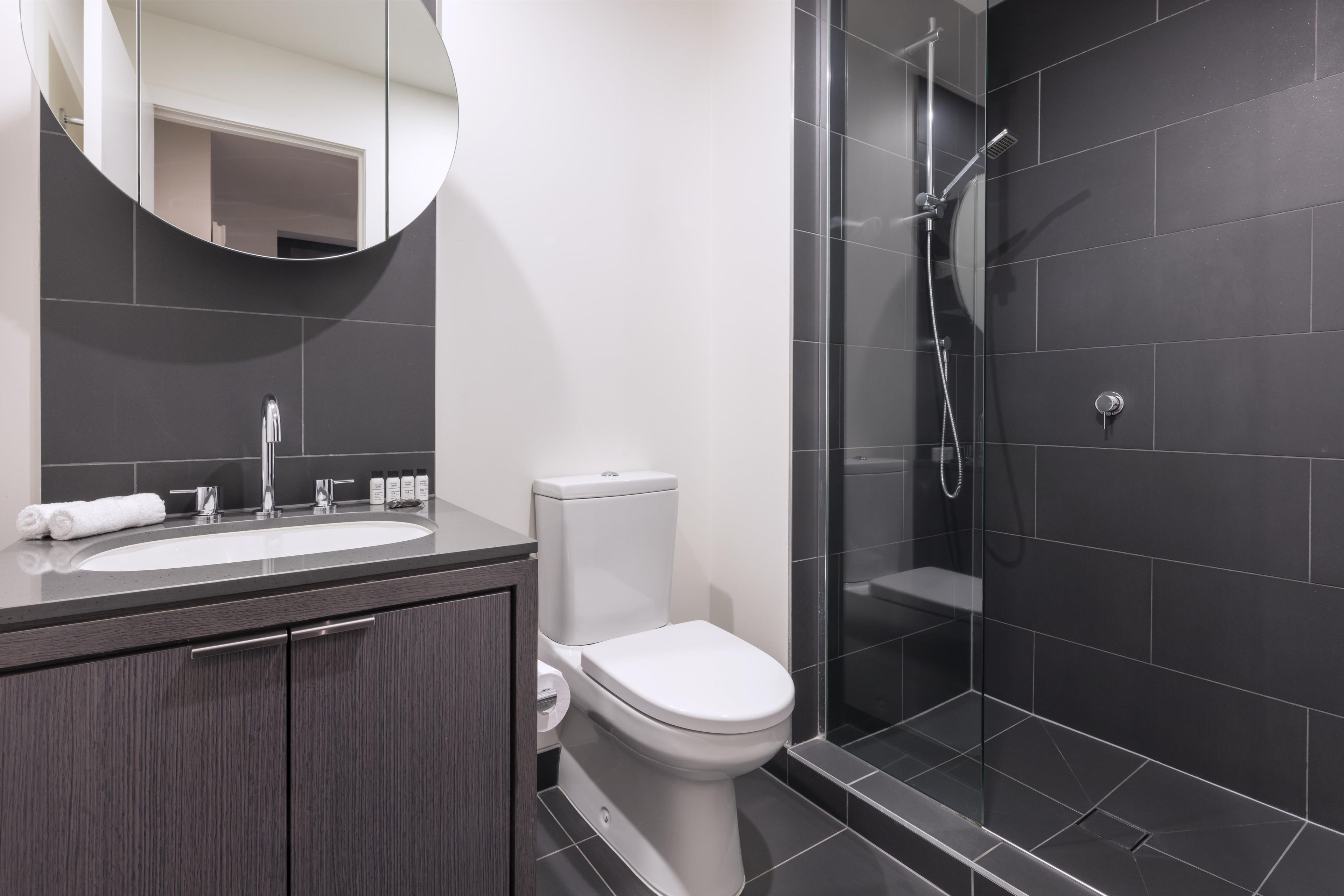 A modern bathroom with a sink, toilet, and shower.