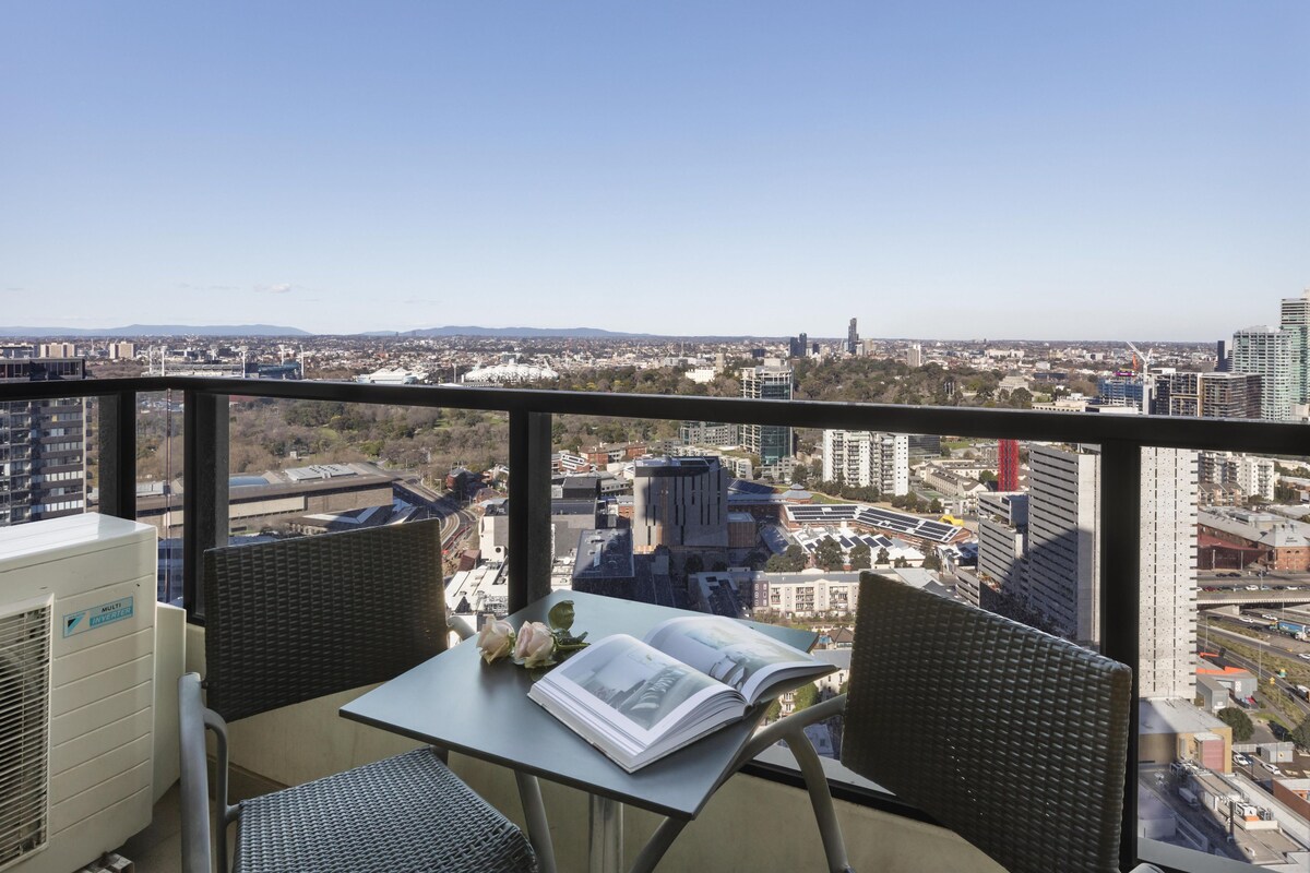 A balcony with a table, chairs, and an open book.