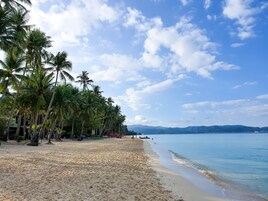 Nyilvános parton, fehér homok, strandlepedők és tengerparti masszázs