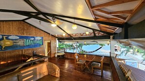 Un interior de madera con comedor, sofá y ventilador de techo.