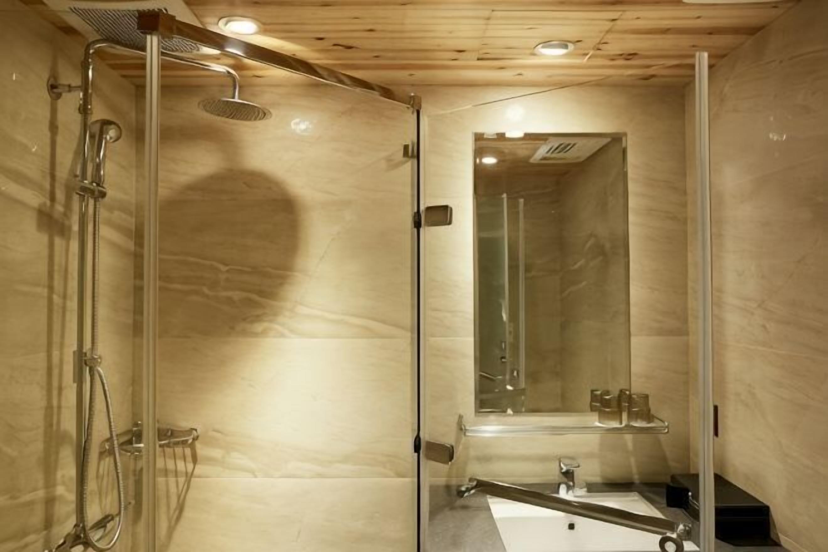 A modern bathroom with a glass shower enclosure, a sink, and a mirror.