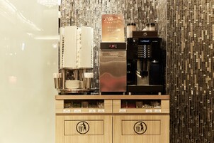 Een koffieapparaat en een drankdispenser in een commerciële omgeving.