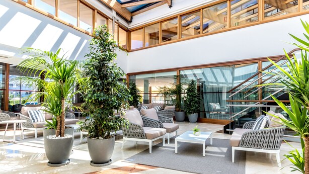 Un vaste espace intérieur doté d’un haut plafond, de grandes fenêtres et de plusieurs types d’aménagements pour s’asseoir.