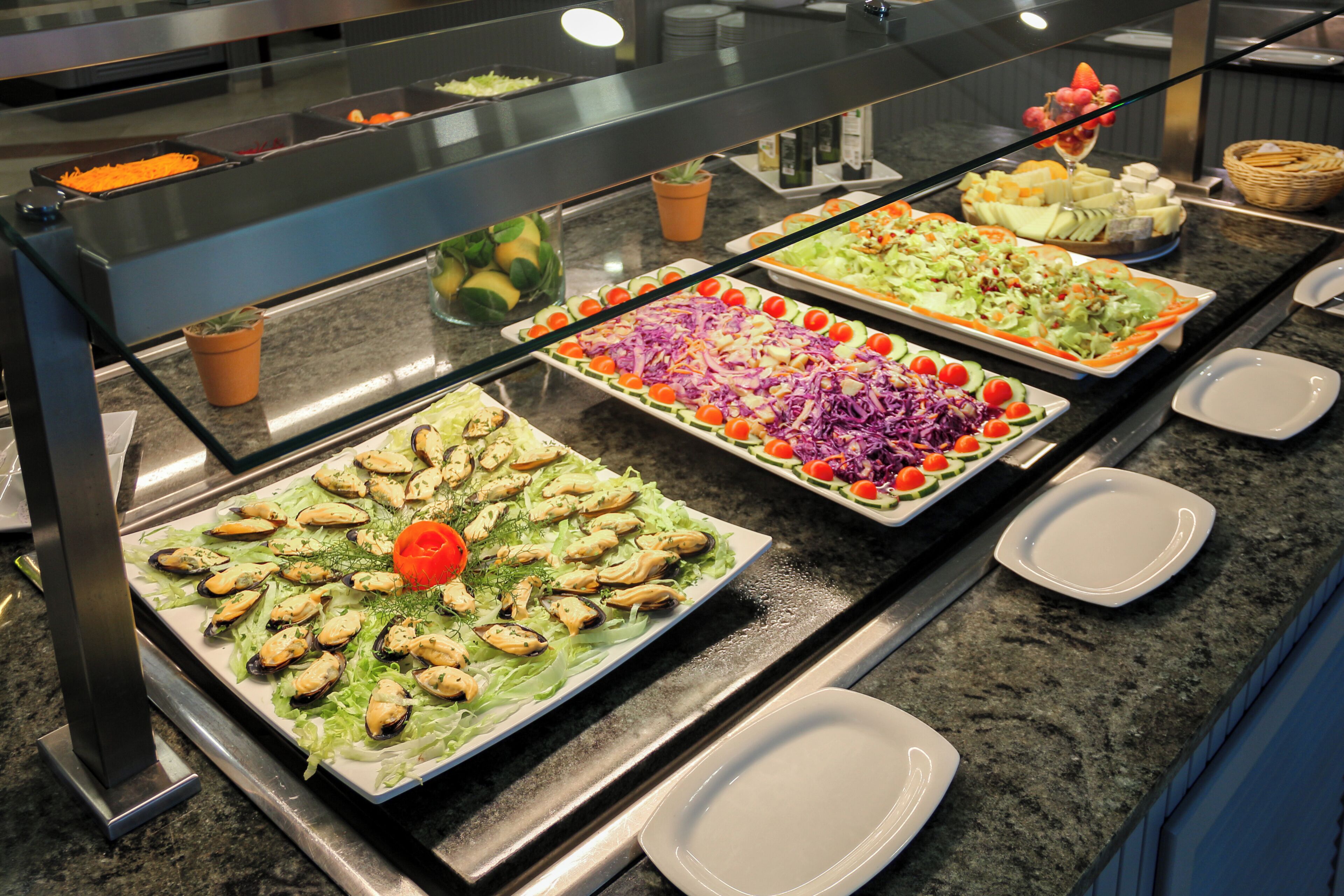 Un buffet proposant une variété de plats, notamment des salades, des fruits de mer et des légumes.