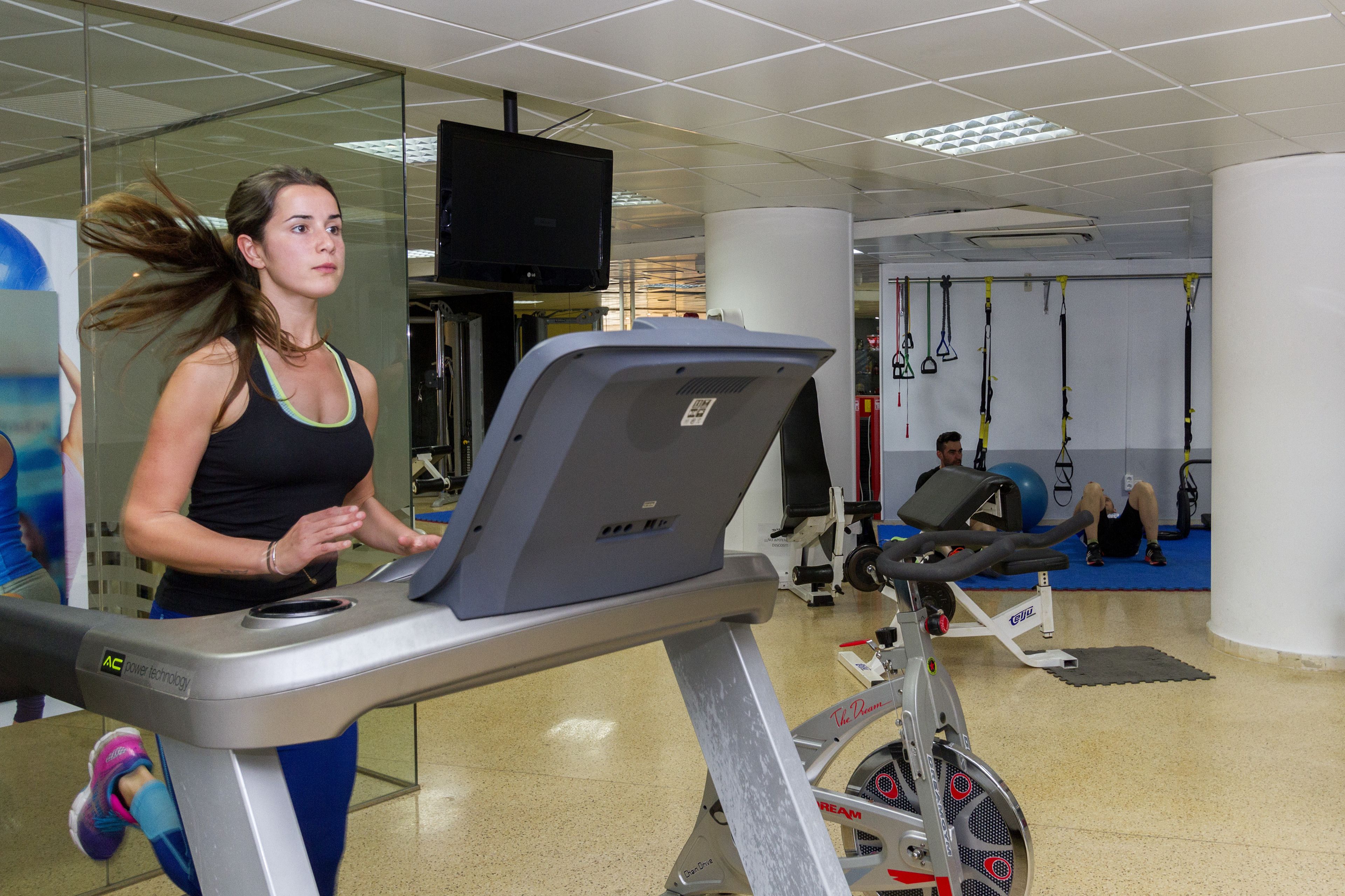 A gym with exercise equipment, including a treadmill and stationary bikes.
