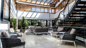 Un vaste espace intérieur doté de hauts plafonds, de grandes fenêtres et d’un escalier moderne.