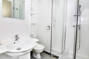 A bathroom with a sink, toilet, and glass shower enclosure. - ibis budget Chateaudun (Chateaudun)