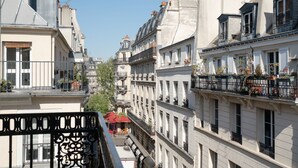 A row of European-style buildings with balconies, some with plants. - Hotel Saint-Louis en L'Isle - Notre-Dame (Paris)