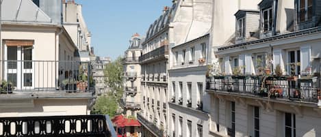 Una hilera de edificios de estilo europeo con balcones, algunos con plantas.