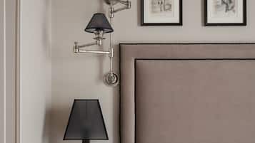 A hotel room with a bed, a nightstand with a lamp, and three framed pictures on the wall.