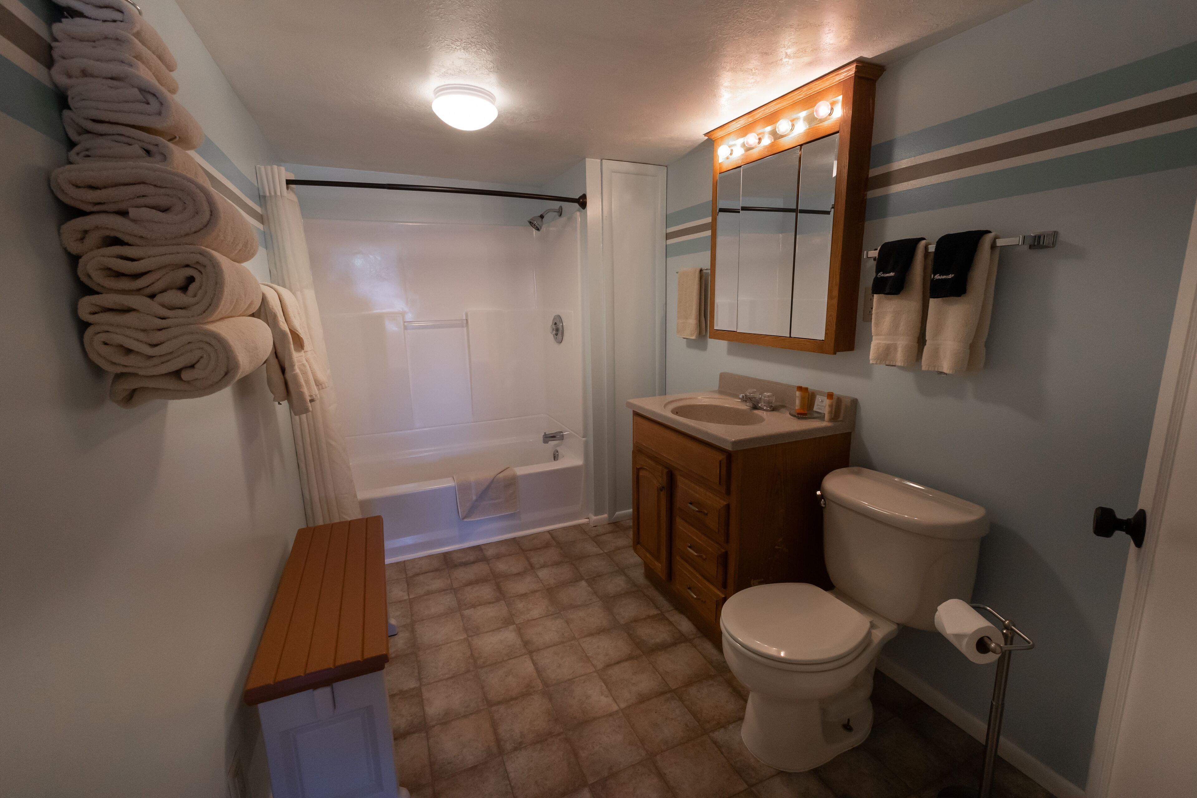 A bathroom with a bathtub, toilet, sink, and towel rack.