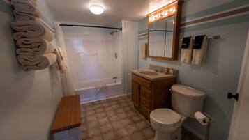 Ein Badezimmer mit Badewanne, Toilette, Waschbecken und Handtuchhalter.