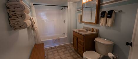 A bathroom with a bathtub, toilet, sink, and towel rack.