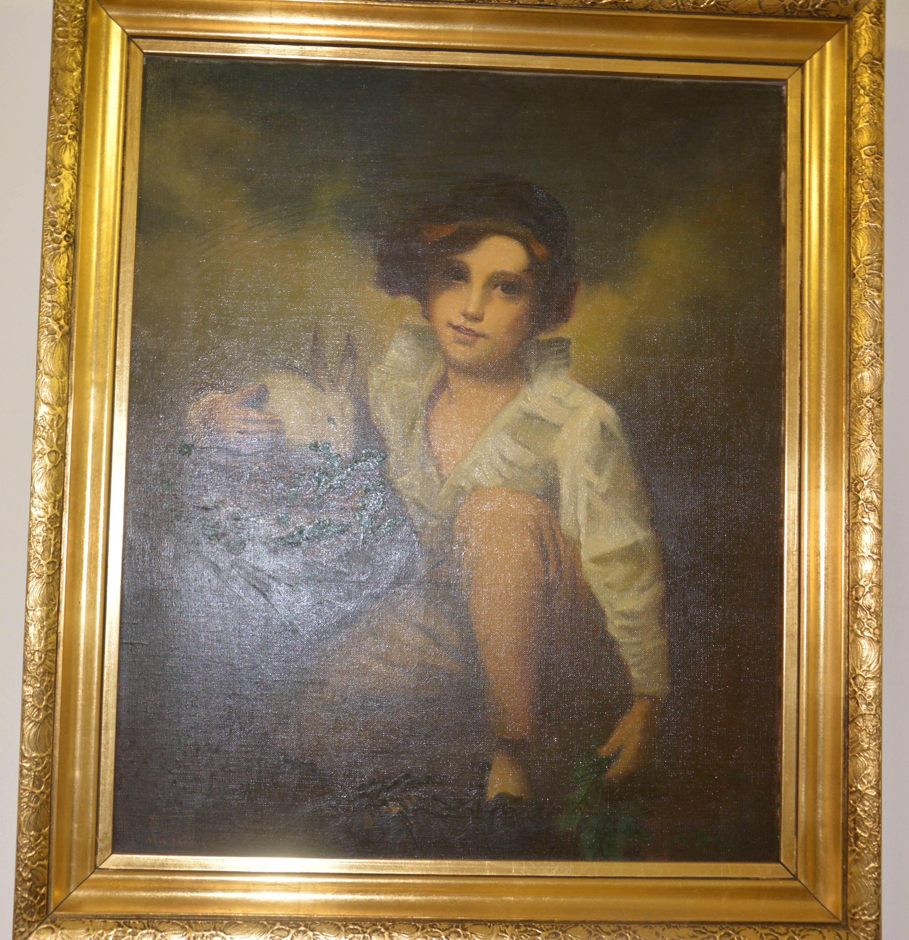 A framed portrait with a gold ornate frame.