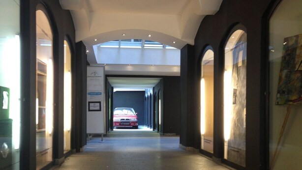 A long, narrow hallway with arched ceilings and a central walkway leading to a bright area. - Hans-Sachs-Gasse 10 (Graz)
