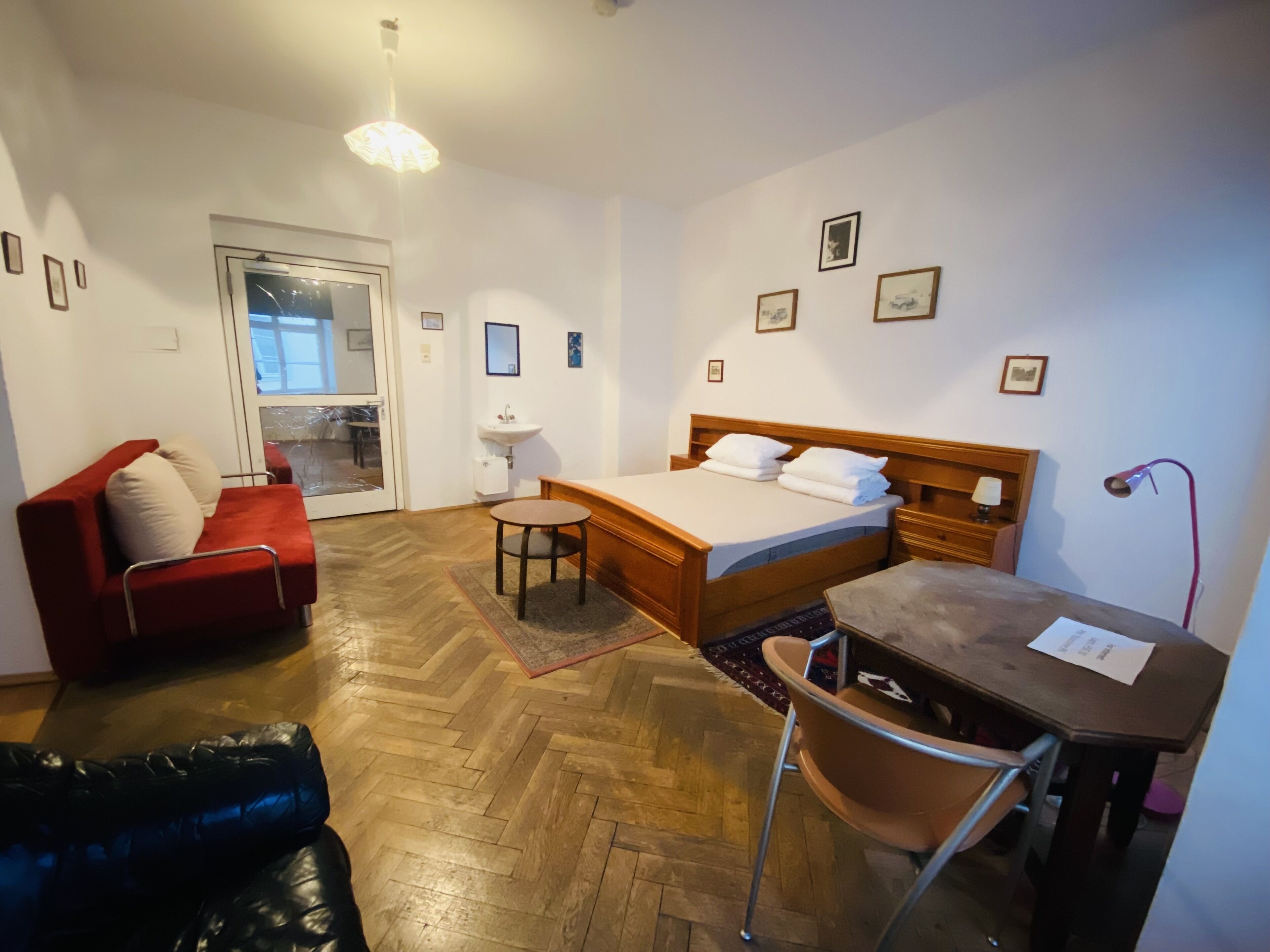 Een hotelkamer met een bed, een bureau, een stoel, een bank en een kleine tafel.