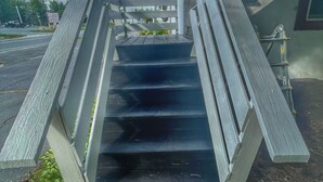 A set of outdoor stairs leading to a building with a red roof. - Open Hearth Inn (Trenton)