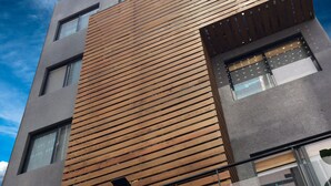 Un bâtiment moderne doté d’une façade en bois, de grandes fenêtres et d’une enseigne avec des caractères chinois.