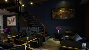 Un intérieur moderne avec un escalier, des meubles en cuir et une carte du monde accrochée au mur.