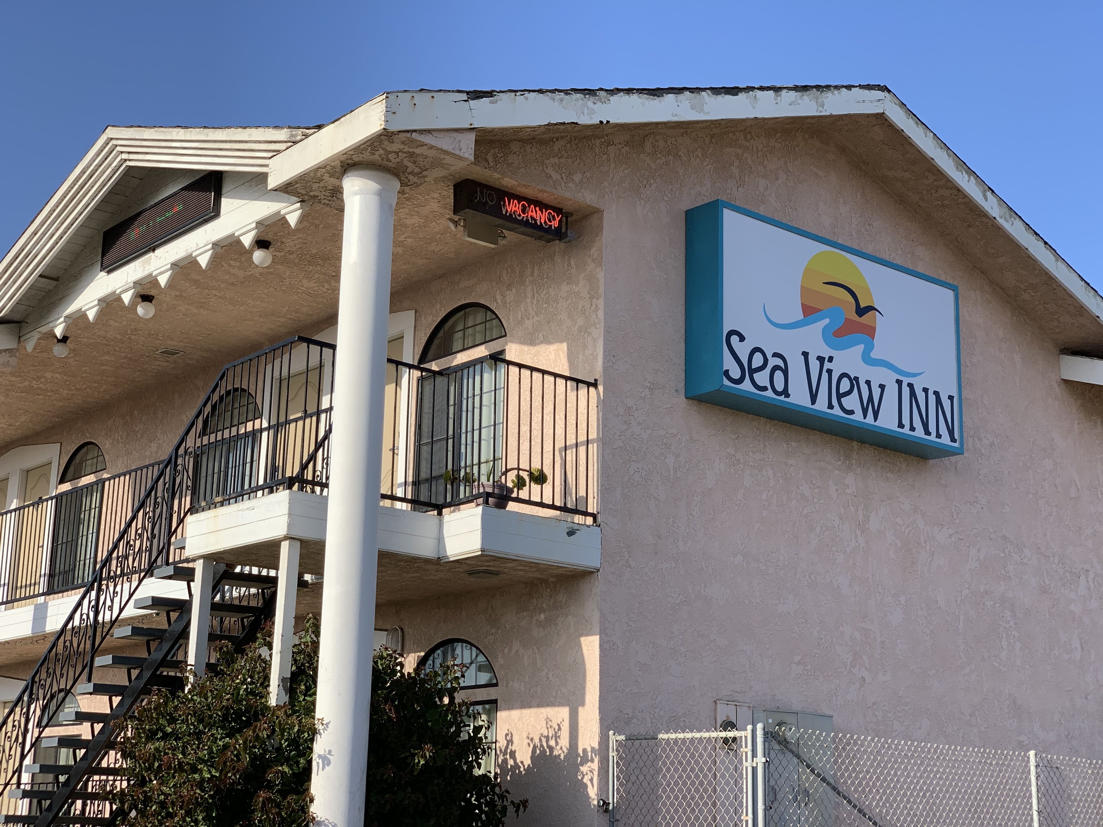 Un edificio con un letrero que dice "Sea View Inn" y un cartel de "No Hay Disponibilidad" sobre la entrada.