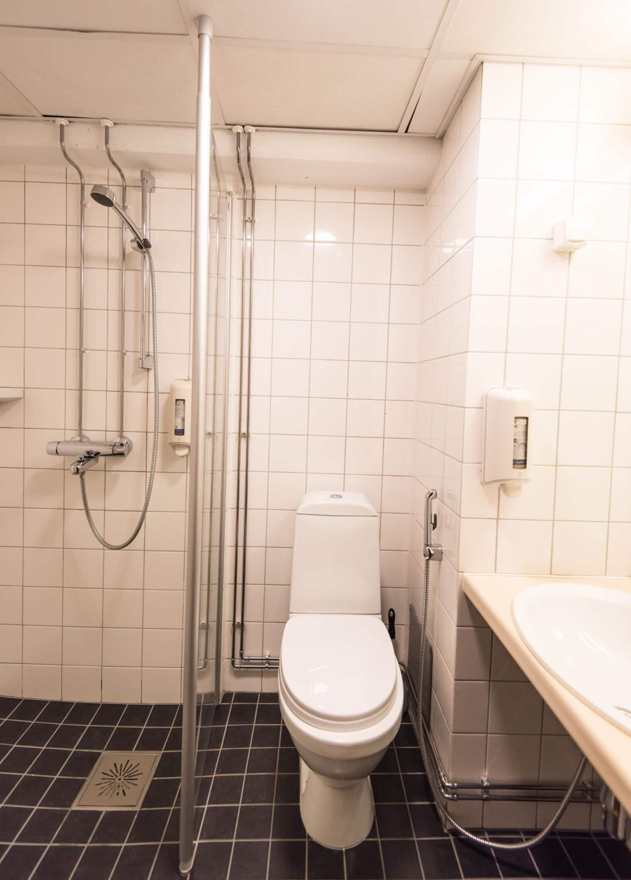 Un baño con inodoro, ducha y lavamanos.