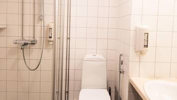 Un baño con inodoro, ducha y lavamanos.