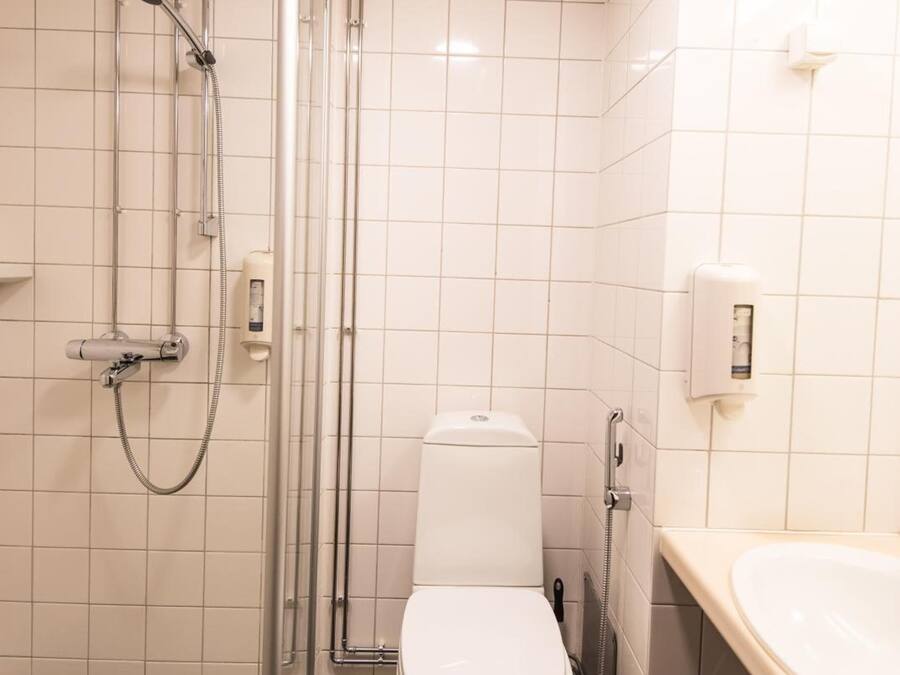 A bathroom with a toilet, a shower, and a sink.