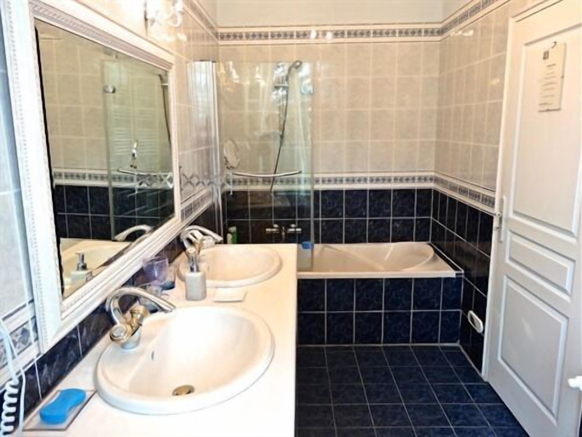 A bathroom with two sinks, a mirror, and a shower.