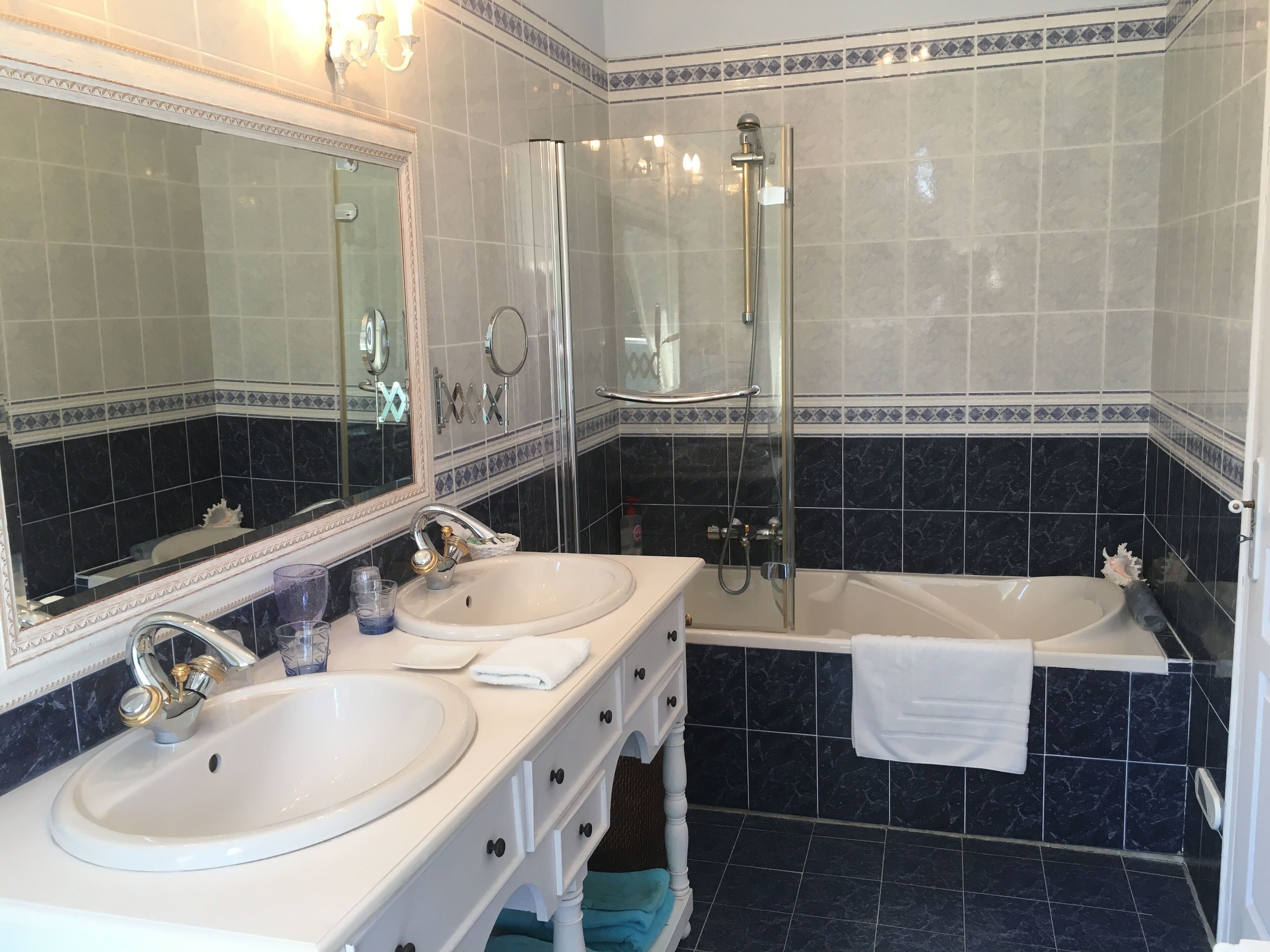 A bathroom with two sinks, a bathtub, and a shower.