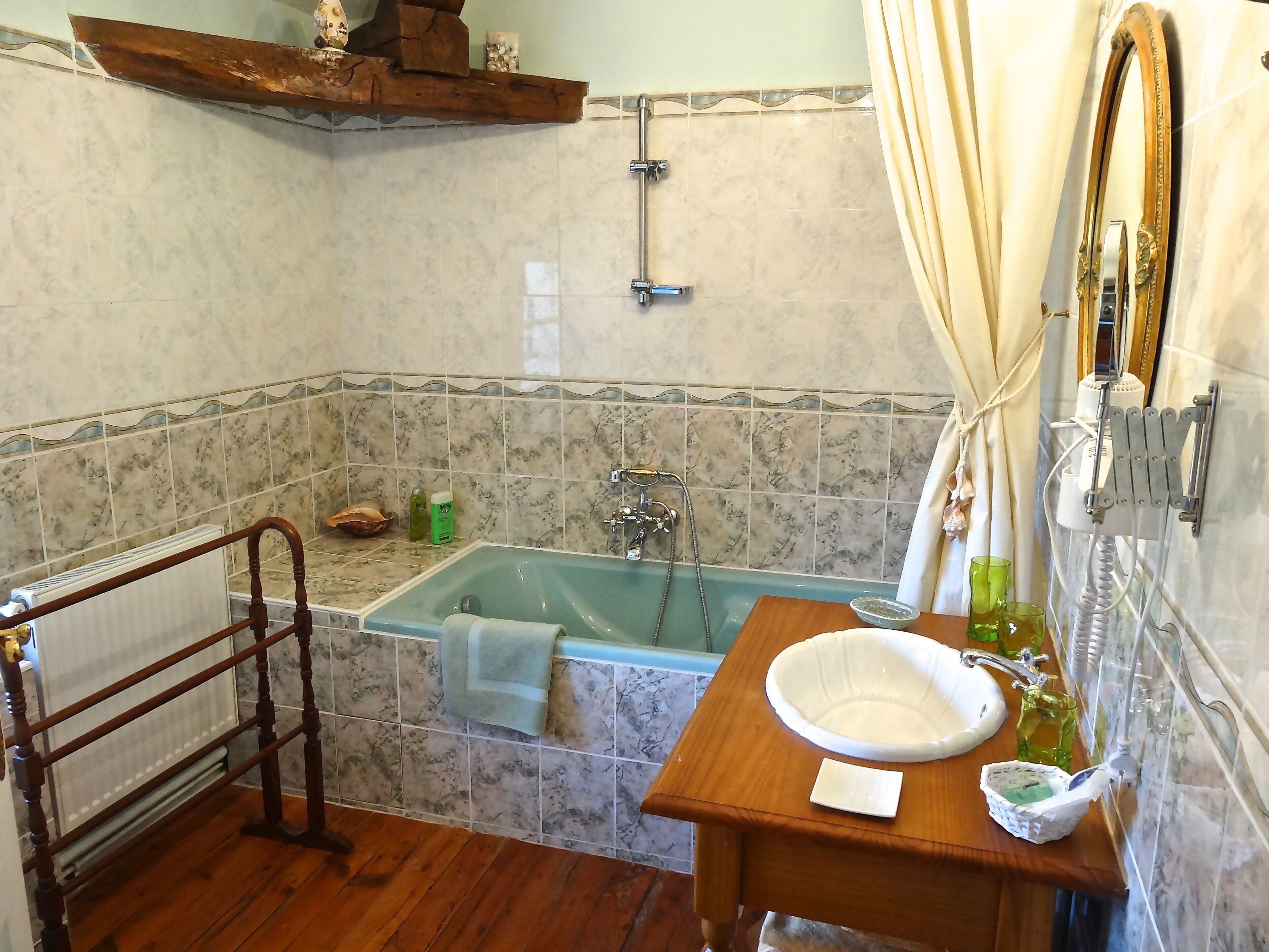 A bathroom with a bathtub, a wooden vanity with a sink, and a towel rack.