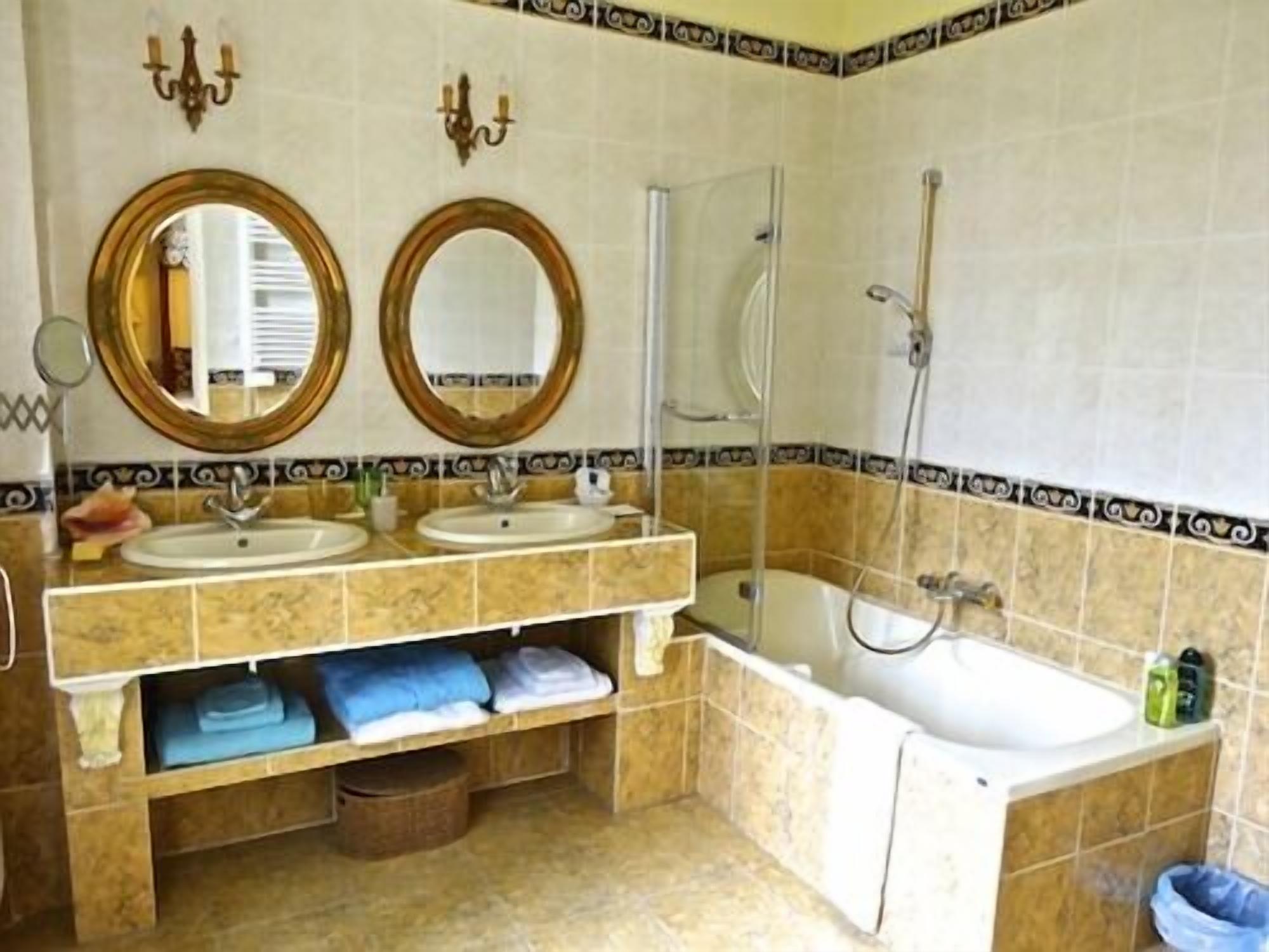 A bathroom with two sinks, a bathtub, and a shower. There are two wall-mounted mirrors and a towel rack with towels.